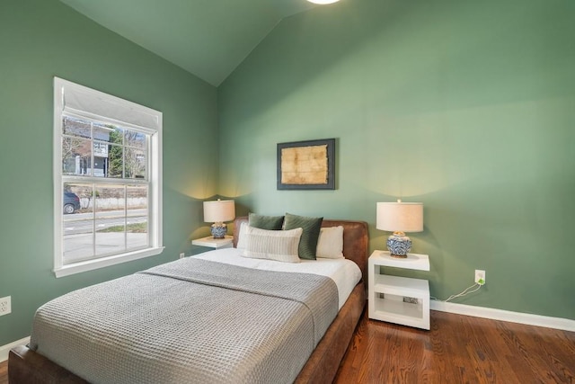 bedroom featuring lofted ceiling, wood finished floors, and baseboards