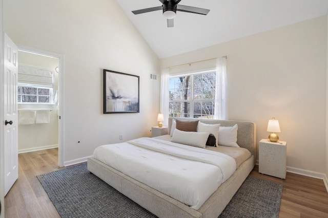 bedroom featuring ceiling fan, light wood-style floors, baseboards, and high vaulted ceiling