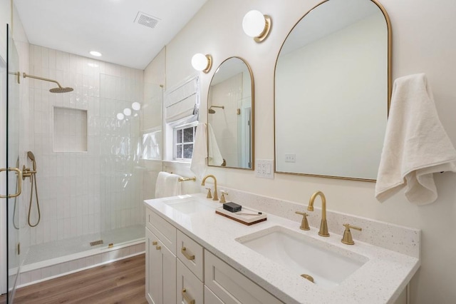 bathroom with a shower stall, visible vents, and a sink