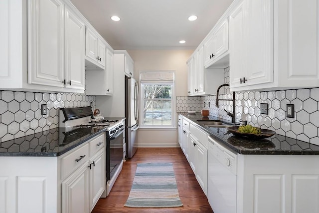 kitchen with gas range, freestanding refrigerator, white dishwasher, white cabinets, and a sink