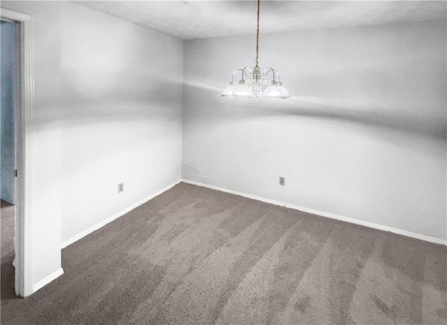 carpeted empty room with a chandelier