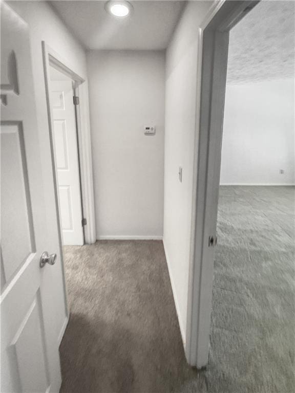 corridor with dark colored carpet