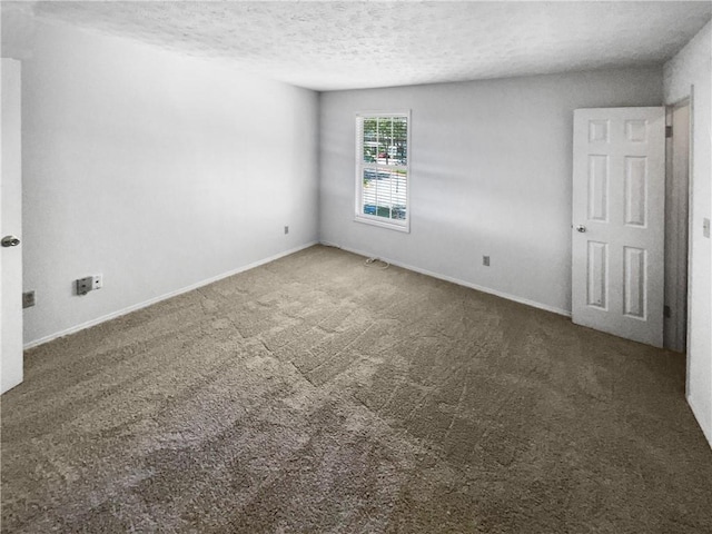 empty room with dark carpet and a textured ceiling