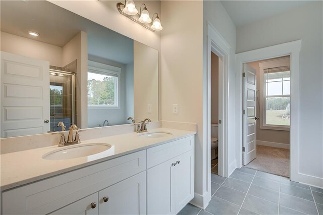 bathroom featuring tile patterned flooring, vanity, toilet, and an enclosed shower