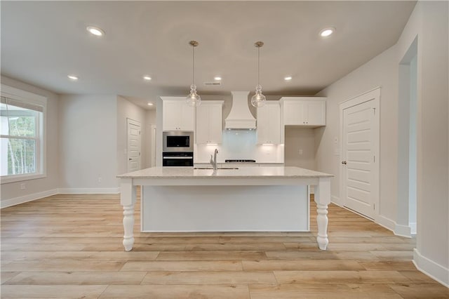 kitchen featuring white cabinets, sink, a kitchen island with sink, and custom exhaust hood