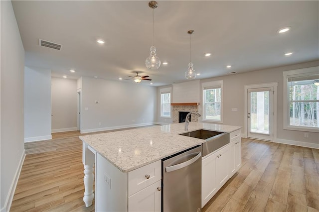 kitchen featuring dishwasher, light wood-type flooring, white cabinetry, and sink