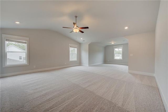 unfurnished room with ceiling fan, light colored carpet, and vaulted ceiling