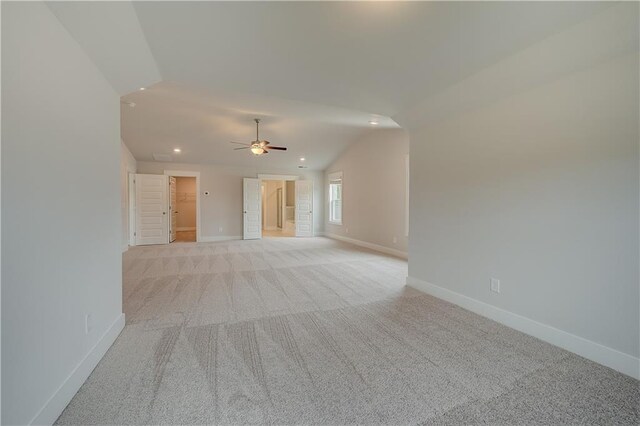 carpeted empty room featuring vaulted ceiling and ceiling fan