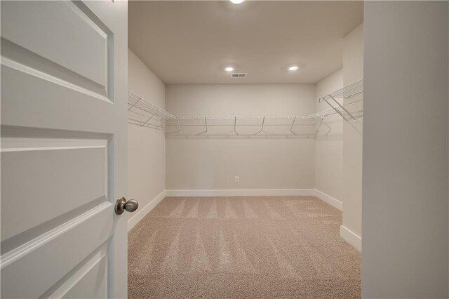 walk in closet featuring light carpet