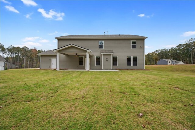 rear view of property with a patio area, ceiling fan, and a yard