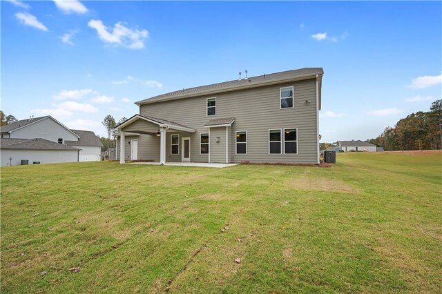 rear view of property featuring a lawn and a patio area