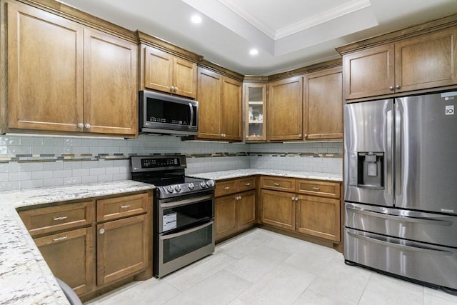 kitchen featuring light stone counters, decorative backsplash, crown molding, appliances with stainless steel finishes, and light tile patterned floors