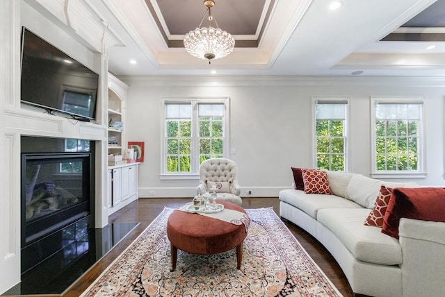 living room with dark hardwood / wood-style floors, a tray ceiling, and ornamental molding