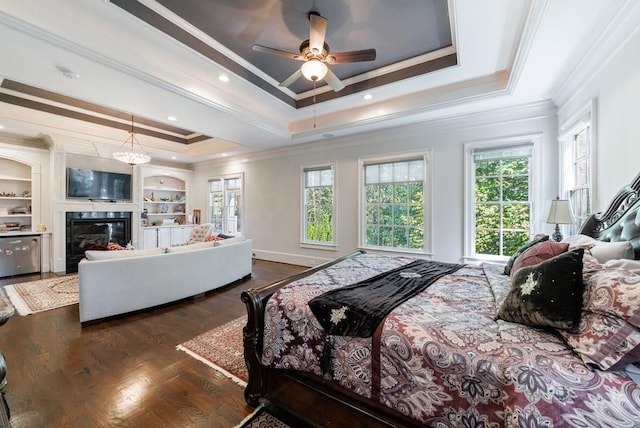 bedroom with crown molding, ceiling fan, a tray ceiling, and dark hardwood / wood-style flooring