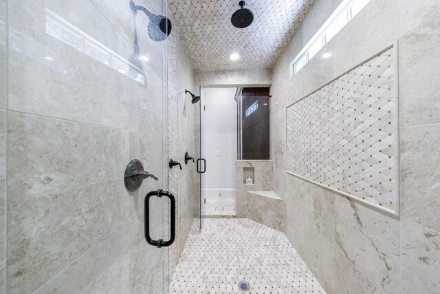 bathroom with walk in shower, tile walls, and a healthy amount of sunlight