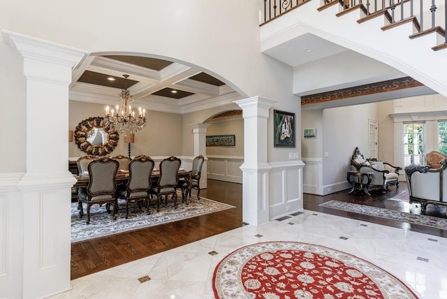 entrance foyer with wood-type flooring, crown molding, coffered ceiling, and a chandelier