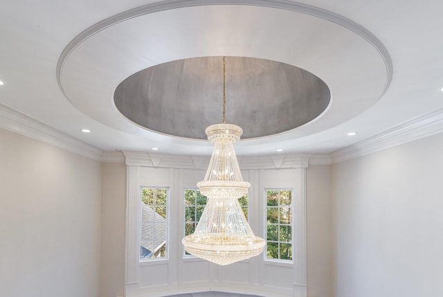 interior details with a raised ceiling, ornamental molding, and an inviting chandelier