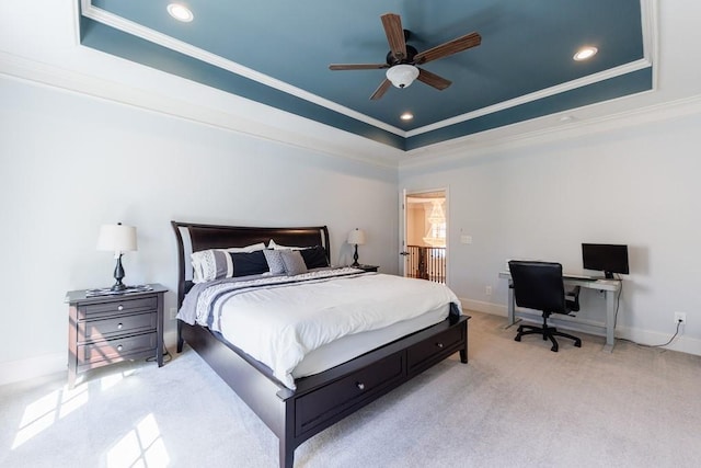 carpeted bedroom featuring ornamental molding, a tray ceiling, and ceiling fan