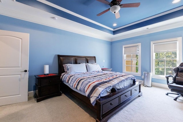 bedroom featuring a raised ceiling, ceiling fan, ornamental molding, and light carpet