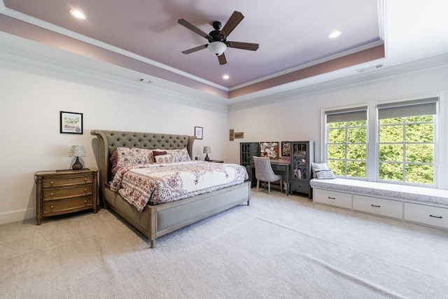 carpeted bedroom with ornamental molding, ceiling fan, and a raised ceiling