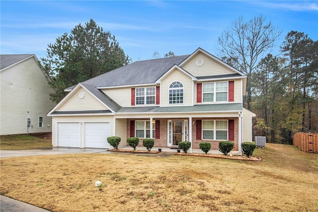 view of front of property featuring a porch, a garage, a front yard, and central AC