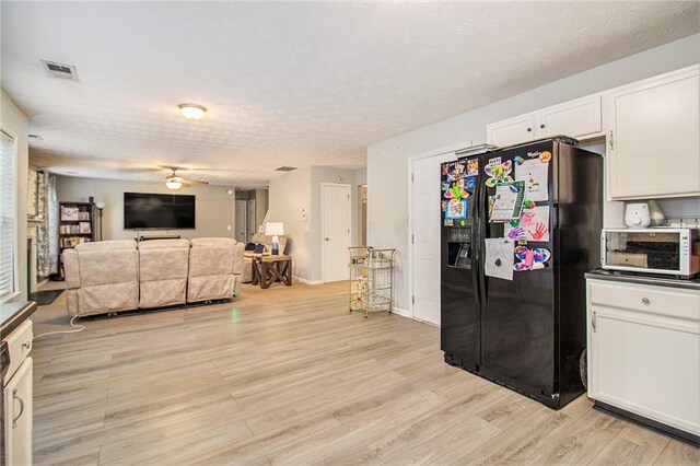 kitchen with black fridge with ice dispenser, a textured ceiling, ceiling fan, white cabinets, and light hardwood / wood-style floors