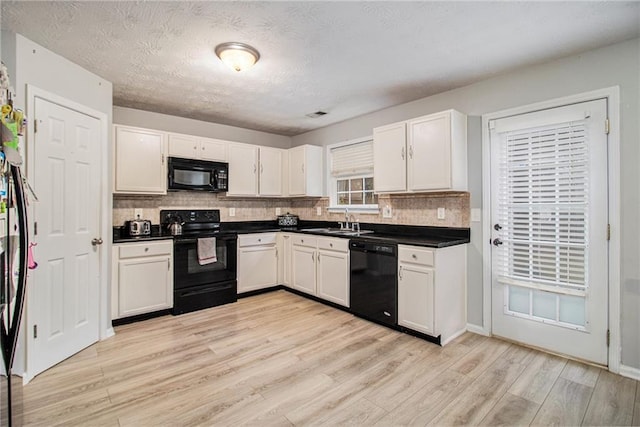 kitchen with backsplash, white cabinets, black appliances, and light hardwood / wood-style floors