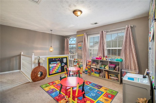 rec room featuring carpet and a textured ceiling