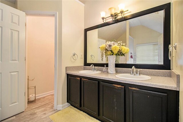 bathroom with lofted ceiling, wood-type flooring, and vanity