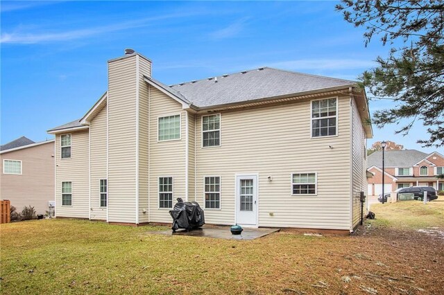 rear view of property featuring a lawn and a patio area