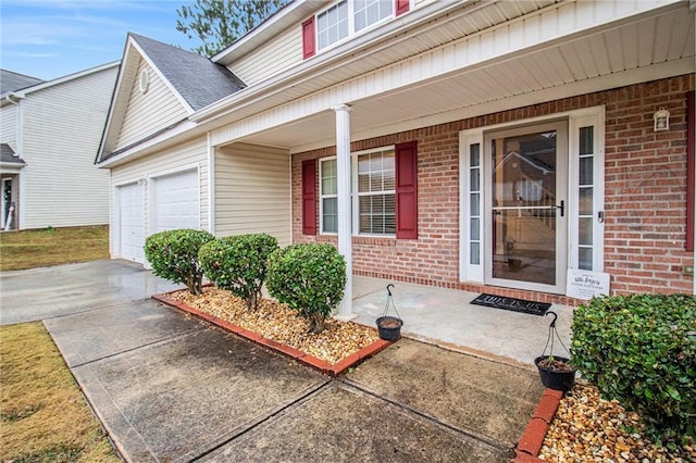 property entrance with covered porch and a garage