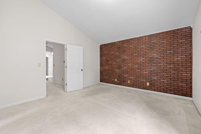 carpeted spare room with brick wall and high vaulted ceiling