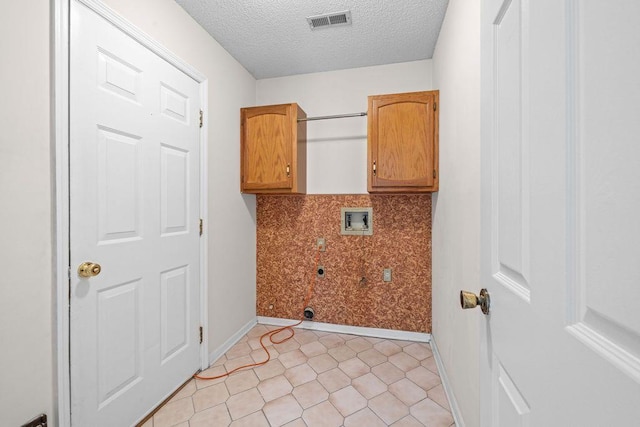 clothes washing area with electric dryer hookup, hookup for a washing machine, cabinets, and a textured ceiling