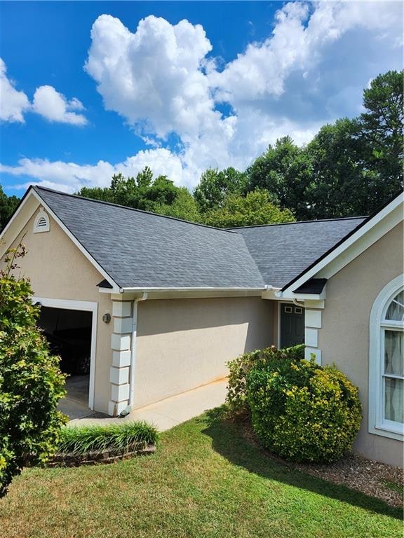 view of side of property featuring a garage and a yard