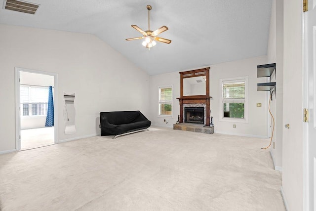 unfurnished living room featuring vaulted ceiling, light colored carpet, ceiling fan, and plenty of natural light