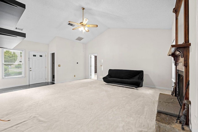 living area featuring ceiling fan, carpet floors, and vaulted ceiling