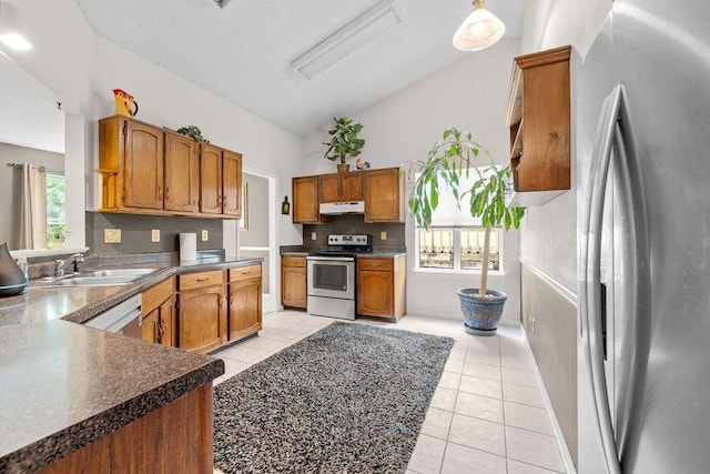 kitchen featuring vaulted ceiling, appliances with stainless steel finishes, sink, and light tile patterned floors