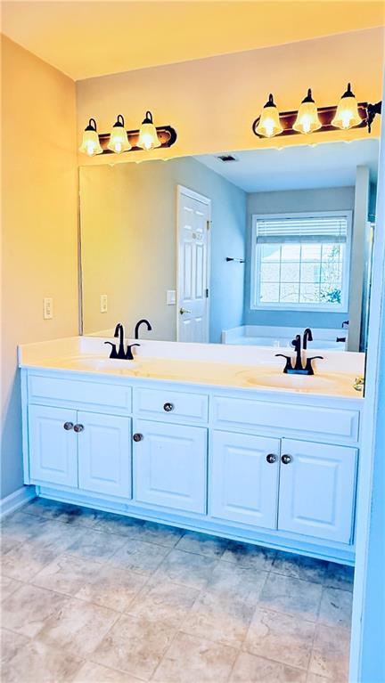 full bathroom featuring double vanity, a sink, and visible vents