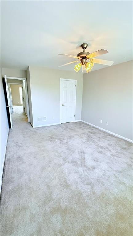 unfurnished room with light carpet, ceiling fan, and baseboards