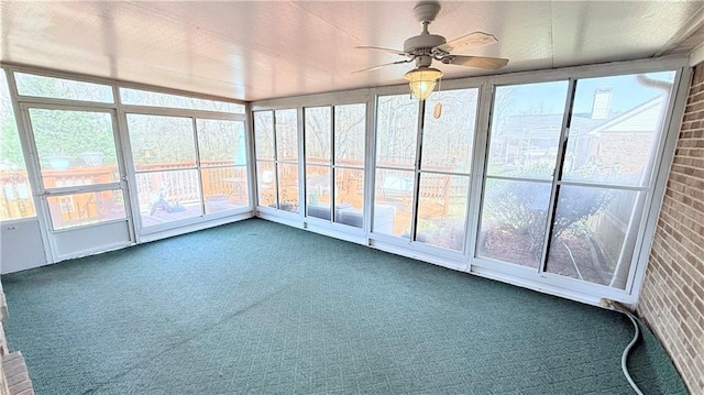 unfurnished sunroom with a ceiling fan