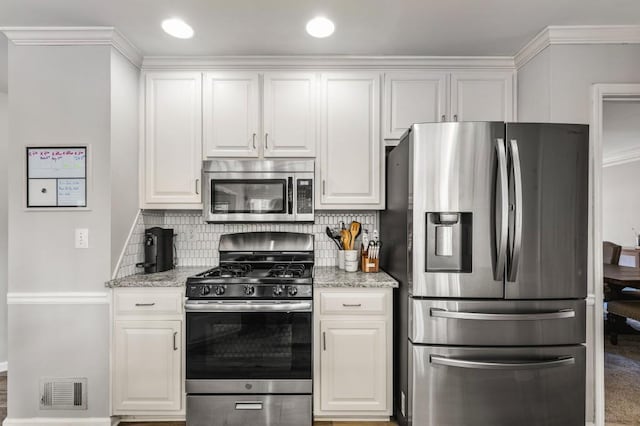 kitchen with white cabinetry, stainless steel appliances, tasteful backsplash, and visible vents