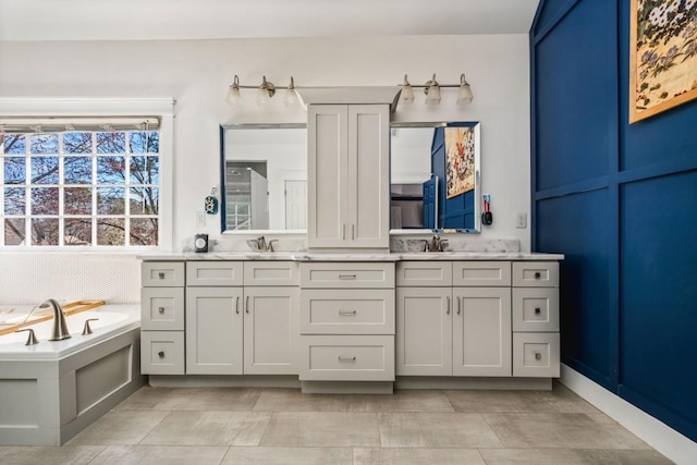 bathroom with double vanity, a sink, and a garden tub