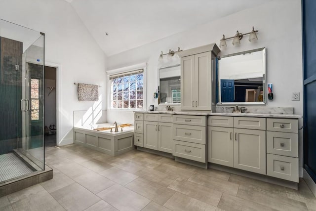 bathroom with double vanity, a stall shower, high vaulted ceiling, a sink, and a bath