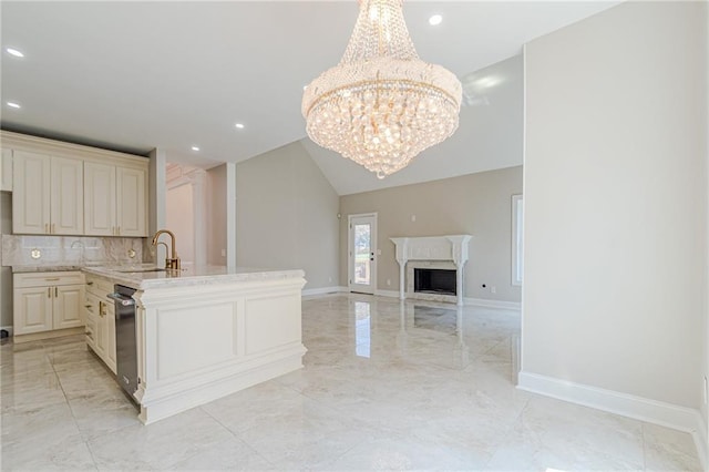 kitchen featuring light stone countertops, stainless steel dishwasher, sink, an inviting chandelier, and cream cabinetry