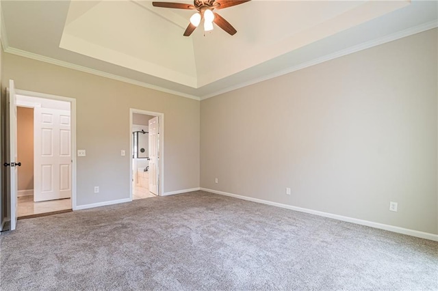 interior space featuring light carpet, ensuite bathroom, ornamental molding, a tray ceiling, and ceiling fan