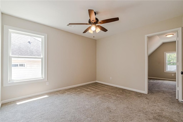 empty room featuring light carpet, vaulted ceiling, and ceiling fan