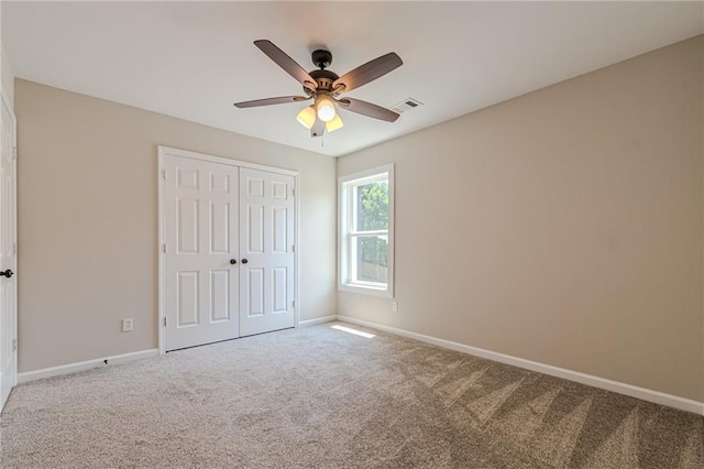 unfurnished bedroom with carpet flooring, ceiling fan, and a closet