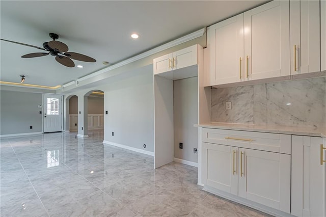 kitchen featuring white cabinets, ceiling fan, and crown molding