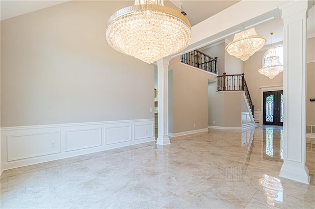 interior space featuring ornate columns, french doors, and an inviting chandelier