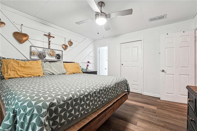 bedroom with baseboards, a ceiling fan, wood finished floors, and visible vents